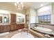 Elegant main bathroom with granite counters, a chandelier, and a luxurious soaking tub with a view at 9820 E Thompson Peak Pkwy # 628, Scottsdale, AZ 85255