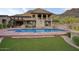 A beautiful pool with steps up to a grassy area, as well as the home's rear elevation at 9820 E Thompson Peak Pkwy # 628, Scottsdale, AZ 85255