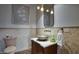 Charming powder room with stylish sink, decorative mirror, stone-look tile walls, attractive light fixture and adjacent toilet at 9820 E Thompson Peak Pkwy # 628, Scottsdale, AZ 85255