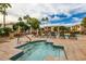 Community pool and spa area with lounge chairs and palm trees at 10030 W Indian School Rd # 165, Phoenix, AZ 85037