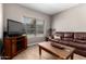 Cozy living room featuring a comfortable leather sofa and natural light at 10030 W Indian School Rd # 165, Phoenix, AZ 85037