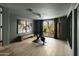 Home gym with updated equipment, ceiling fan, and neutral paint with views of the surrounding landscape at 10795 E Sutherland Way, Scottsdale, AZ 85262