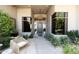 Elegant home entrance with woven chairs, lush landscaping, and a modern front door at 10795 E Sutherland Way, Scottsdale, AZ 85262