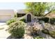Charming home with desert landscaping, mature trees, cacti, and a decorative front gate entry at 10795 E Sutherland Way, Scottsdale, AZ 85262