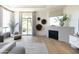 Bright and airy main bedroom seating area with fireplace and floor-to-ceiling windows overlooking lush scenery at 10795 E Sutherland Way, Scottsdale, AZ 85262