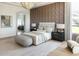 This large main bedroom offers a cozy seating area, calming color palette, and patterned accent wall at 10795 E Sutherland Way, Scottsdale, AZ 85262