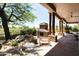 Inviting covered patio featuring a stacked stone fireplace and comfortable seating at 10795 E Sutherland Way, Scottsdale, AZ 85262