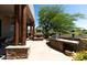 Covered outdoor kitchen with built-in grill, pizza oven and stone accents on patio at 10795 E Sutherland Way, Scottsdale, AZ 85262