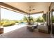 Inviting covered patio with comfortable seating overlooking a private pool and landscaped backyard at 10795 E Sutherland Way, Scottsdale, AZ 85262