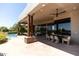 Outdoor dining and lounge area with covered patio and mature desert landscaping at 10795 E Sutherland Way, Scottsdale, AZ 85262