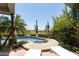 Inviting swimming pool and spa surrounded by desert landscaping and mature palm trees at 10795 E Sutherland Way, Scottsdale, AZ 85262