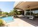 Stunning pool with covered patio, sleek furniture and desert landscaping in backyard at 10795 E Sutherland Way, Scottsdale, AZ 85262