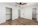 Bedroom with wood-look floors, ceiling fan, closet, and view of the ensuite bath at 1308 N 71St St, Scottsdale, AZ 85257
