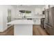 Modern kitchen featuring white cabinets, stainless steel appliances, and an island with quartz countertop at 1308 N 71St St, Scottsdale, AZ 85257