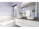 Elegant bathroom features a soaking tub, dual vessel sinks, and modern fixtures at 13628 W San Miguel Ave, Litchfield Park, AZ 85340