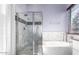 Contemporary bathroom featuring a glass-enclosed shower, soaking tub, and modern finishes at 13628 W San Miguel Ave, Litchfield Park, AZ 85340
