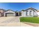 Charming single-story home featuring a well-manicured lawn, wide driveway, and attached two-car garage at 13628 W San Miguel Ave, Litchfield Park, AZ 85340