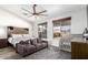 Cozy main bedroom featuring a king bed, comfortable sofa, natural light, and stylish ceiling fan at 13628 W San Miguel Ave, Litchfield Park, AZ 85340