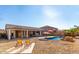Inviting pool area features desert landscaping, nearby patio seating, and charming rock features at 13628 W San Miguel Ave, Litchfield Park, AZ 85340