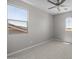 An empty bedroom with two large windows allowing for natural light at 15626 W Georgia Dr, Surprise, AZ 85379