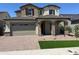 Charming two-story home featuring a stone facade, a two-car garage, and manicured landscaping at 15626 W Georgia Dr, Surprise, AZ 85379