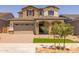 Charming two-story home showcasing stone accents, a two-car garage, and well-manicured landscaping at 15626 W Georgia Dr, Surprise, AZ 85379