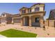 Charming two-story home showcasing stone accents, a two-car garage, and low-water landscaping at 15626 W Georgia Dr, Surprise, AZ 85379