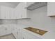 White kitchen cabinets with stainless steel hood and gray backsplash at 15626 W Georgia Dr, Surprise, AZ 85379