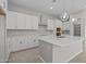 Spacious kitchen with white cabinets, stainless hood, and a large center island with a sink at 15626 W Georgia Dr, Surprise, AZ 85379