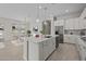 Open-concept kitchen with white cabinets, stainless appliances, and island sink overlooking the dining room at 15626 W Georgia Dr, Surprise, AZ 85379