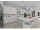 Modern kitchen boasts white cabinetry, stainless steel appliances, and a center island with bar stool seating at 15626 W Georgia Dr, Surprise, AZ 85379