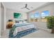 Serene primary bedroom with large windows, ceiling fan, and ensuite bathroom at 15626 W Georgia Dr, Surprise, AZ 85379