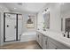 Bathroom with dual vanities, soaking tub, and a glass-enclosed shower at 15784 W Georgia W Dr, Surprise, AZ 85379