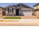Charming single-story home featuring a two-car garage, stone accents, and a well-maintained lawn at 15784 W Georgia W Dr, Surprise, AZ 85379