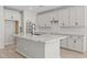 A modern kitchen with white cabinets, granite countertops, stainless steel appliances and a black faucet on the island at 15784 W Georgia W Dr, Surprise, AZ 85379