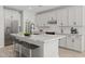 Elegant kitchen showcasing white cabinetry, stainless steel appliances, granite countertops and sleek, modern bar stools at 15784 W Georgia W Dr, Surprise, AZ 85379