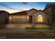 Exterior elevation of single story home at dusk with red tile roof, two-car garage, and desert landscaping at 15796 W Georgia W Dr, Surprise, AZ 85379