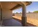 Shaded outdoor patio with new backyard area enclosed by block fencing at 15796 W Georgia W Dr, Surprise, AZ 85379