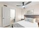 Cozy bedroom with a ceiling fan, bed, and view into an ensuite bathroom at 16436 N 64Th Pl, Scottsdale, AZ 85254