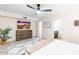 Spacious bedroom features a ceiling fan, desert-themed TV art, and access to the bathroom at 16436 N 64Th Pl, Scottsdale, AZ 85254