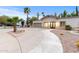 Charming single story home with a circular driveway, desert landscaping, and a two-car garage at 16436 N 64Th Pl, Scottsdale, AZ 85254