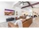 Open living room featuring vaulted ceilings, a brick fireplace, leather seating, and tile floors at 16436 N 64Th Pl, Scottsdale, AZ 85254