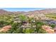 Stunning aerial view of a property with a golf course, water feature, and lush landscaping with mountains in the background at 21166 W Main St, Buckeye, AZ 85396