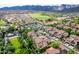 Aerial view of charming red-roofed homes near golf course, a parking lot, and stunning mountain views in a desirable community at 21166 W Main St, Buckeye, AZ 85396