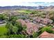 Stunning aerial view of homes with red tile roofs near scenic mountains and a lush green golf course in a vibrant community at 21166 W Main St, Buckeye, AZ 85396
