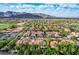 Expansive aerial view of a community featuring red-tiled roofs, lush greenery, and a beautiful mountain range in the background at 21166 W Main St, Buckeye, AZ 85396