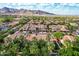Aerial view of beautiful red-tiled homes surrounded by lush greenery in a vibrant community with mountain views on the horizon at 21166 W Main St, Buckeye, AZ 85396