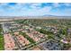 Wide aerial view of red-tiled homes, palm trees, a golf course, and a parking lot in a vibrant, flourishing community at 21166 W Main St, Buckeye, AZ 85396