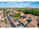 Wide aerial shot showcases a residential community with tile roofs, mountain views and tree-lined streets at 21166 W Main St, Buckeye, AZ 85396