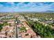 Wide aerial shot showcases red-tiled homes, tropical palm trees, and various community buildings under a bright blue sky at 21166 W Main St, Buckeye, AZ 85396